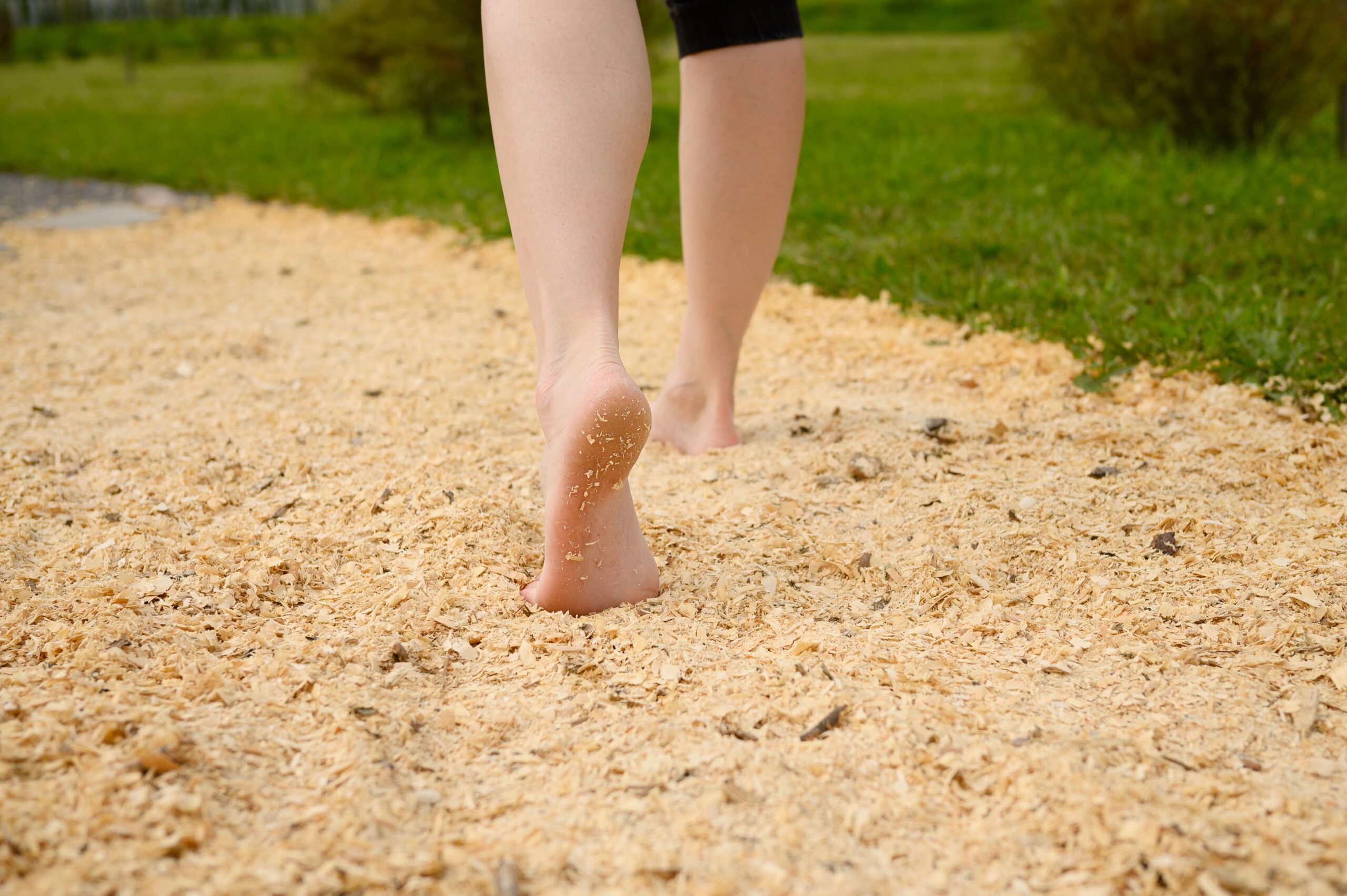 Woman,Walking,Barefoot,On,Sawdust,Massage,Eco-tactile,Path,In,Park,